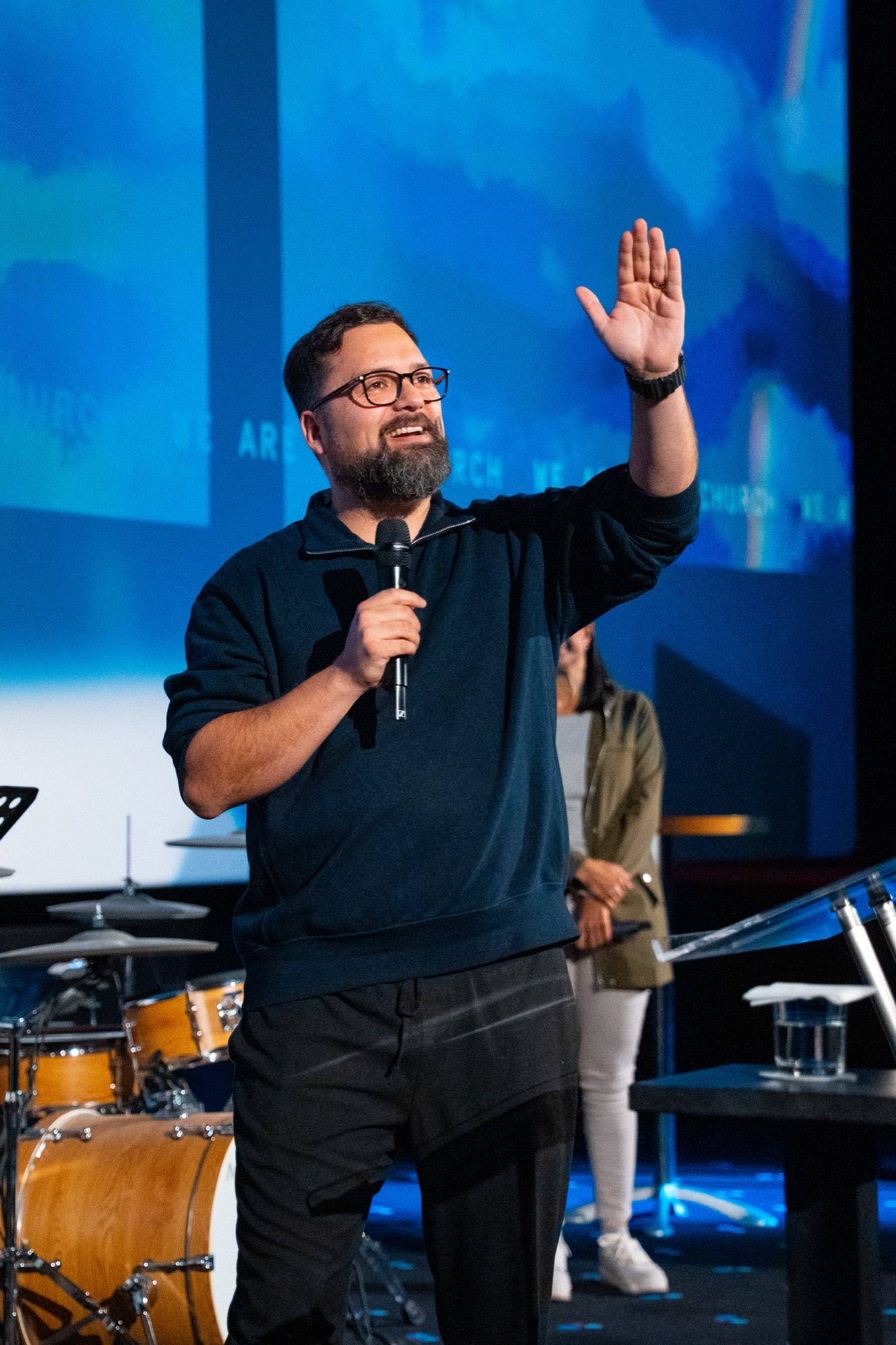 Pastor saludando desde el escenario